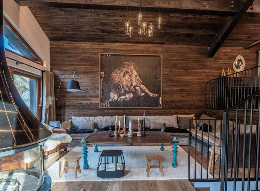 Experience rustic luxury in this stunning mountain lodge living room, featuring a large lion artwork as a focal point.