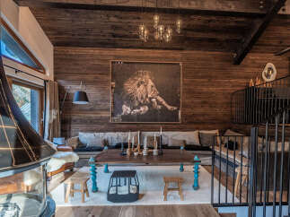 Experience rustic luxury in this stunning mountain lodge living room, featuring a large lion artwork as a focal point.