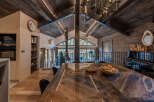 Experience rustic luxury in this stunning mountain retreat, featuring a grand wooden dining table perfect for gatherings.
