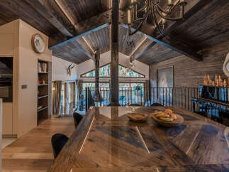 Experience rustic luxury in this stunning mountain retreat, featuring a grand wooden dining table perfect for gatherings.