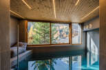 Experience luxury and relaxation in this stunning indoor pool area, featuring a serene ambiance and breathtaking mountain views.