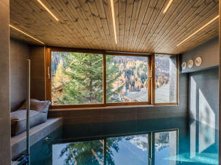 Experience luxury and relaxation in this stunning indoor pool area, featuring a serene ambiance and breathtaking mountain views.