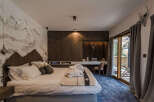Experience alpine luxury in this beautifully appointed bedroom, featuring a striking mountain mural and rich wood paneling.