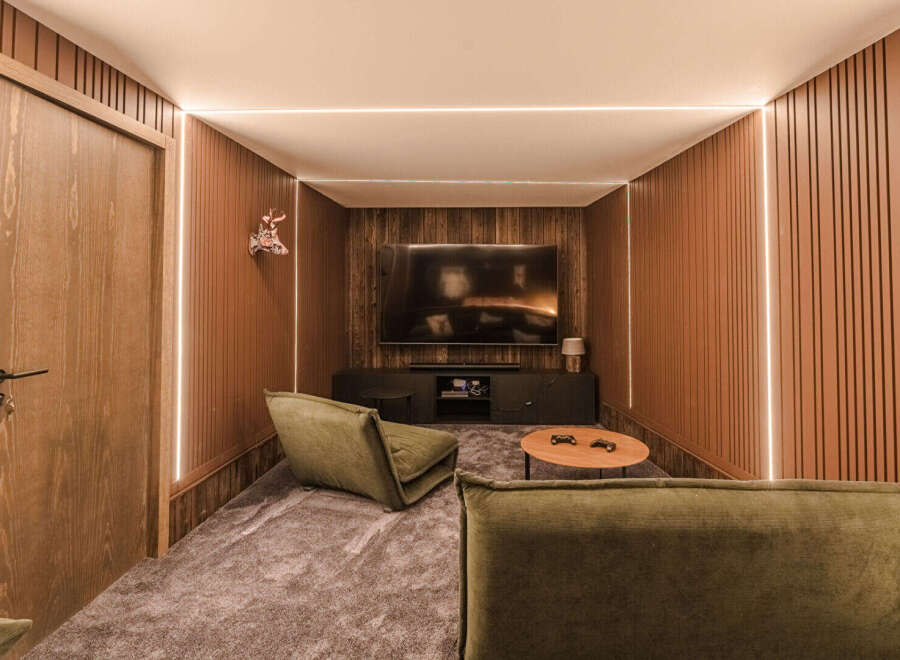 Experience ultimate relaxation in this modern home theater, featuring plush green seating and a large screen for immersive entertainment.