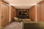 Experience ultimate relaxation in this modern home theater, featuring plush green seating and a large screen for immersive entertainment.
