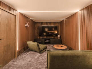Experience ultimate relaxation in this modern home theater, featuring plush green seating and a large screen for immersive entertainment.