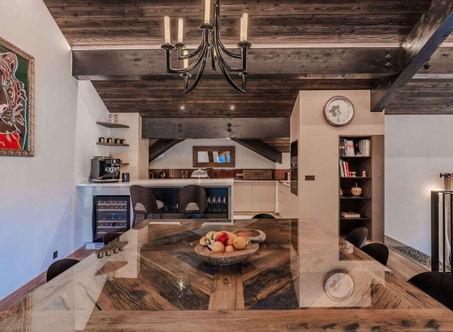 Experience luxury living in this stunning dining area, featuring a unique wooden dining table with a glass top, perfect for hosting memorable meals.