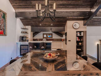 Experience luxury living in this stunning dining area, featuring a unique wooden dining table with a glass top, perfect for hosting memorable meals.