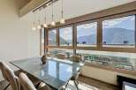 Experience breathtaking mountain views from this elegant dining room, featuring a sleek marble-top table and comfortable upholstered chairs.