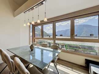 Experience breathtaking mountain views from this elegant dining room, featuring a sleek marble-top table and comfortable upholstered chairs.