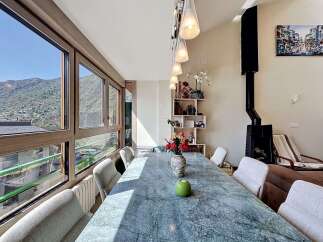 Experience breathtaking mountain views from this stunning dining room, featuring a large marble-top table perfect for gatherings.