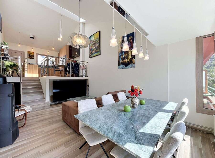 Experience modern living in this spacious multi-level home, featuring an open-concept living area with a sleek dining set and a stylish kitchen.