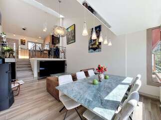 Experience modern living in this spacious multi-level home, featuring an open-concept living area with a sleek dining set and a stylish kitchen.