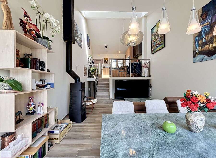 Experience modern living in this spacious, open-concept home featuring a striking black wood-burning stove and a sleek, multi-level design.