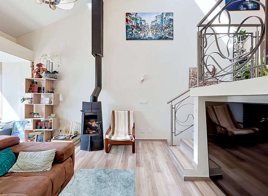 This spacious living room boasts a modern aesthetic with a striking black wood-burning stove as a focal point.