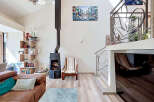 This spacious living room boasts a modern aesthetic with a striking black wood-burning stove as a focal point.