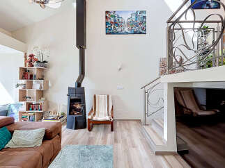 This spacious living room boasts a modern aesthetic with a striking black wood-burning stove as a focal point.