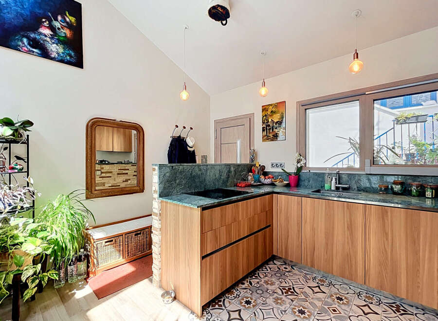 Discover this charming kitchen featuring sleek wooden cabinetry and a stunning marble countertop.
