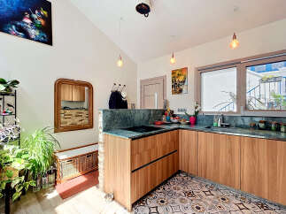 Discover this charming kitchen featuring sleek wooden cabinetry and a stunning marble countertop.