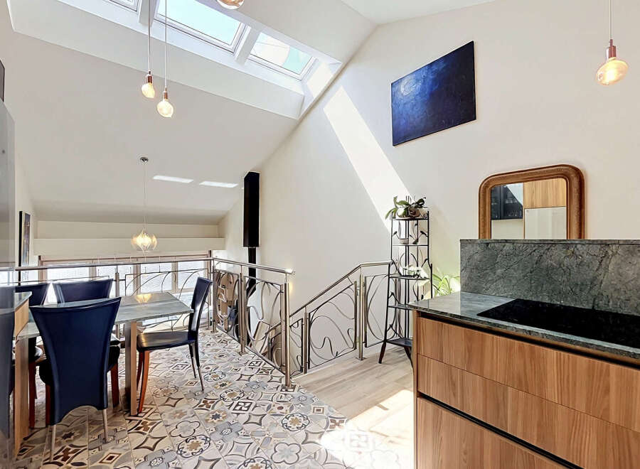 This modern dining area boasts a unique vaulted ceiling with skylights, flooding the space with natural light.