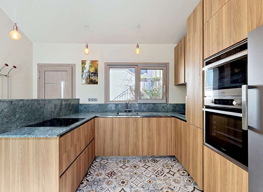 Experience modern living in this beautifully designed kitchen, featuring sleek wooden cabinetry and elegant marble countertops.