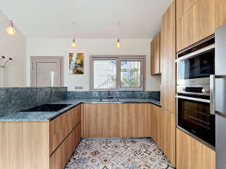 Experience modern living in this beautifully designed kitchen, featuring sleek wooden cabinetry and elegant marble countertops.