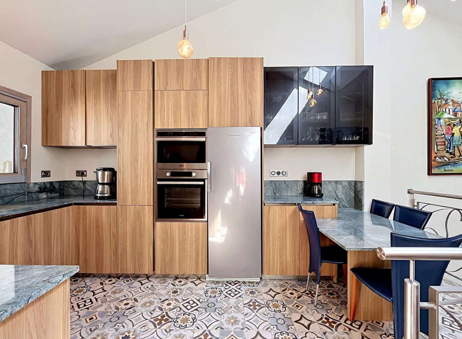 Experience modern living in this stunning kitchen featuring sleek wooden cabinetry and integrated stainless steel appliances.