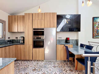 Experience modern living in this stunning kitchen featuring sleek wooden cabinetry and integrated stainless steel appliances.