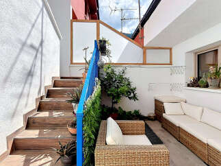 Enjoy outdoor living with this charming patio featuring comfortable wicker seating and a stylish outdoor sofa.