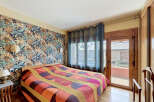 Step into this inviting bedroom featuring a striking tropical-themed wallpaper that adds a vibrant touch to the space.
