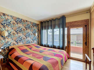 Step into this inviting bedroom featuring a striking tropical-themed wallpaper that adds a vibrant touch to the space.