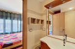 This charming property features a well-appointed bathroom with a modern sink and vanity, complemented by elegant tiled walls and wooden accents.