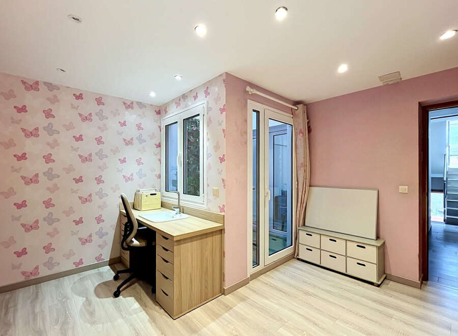 This charming room features a playful butterfly-themed wallpaper, creating a whimsical atmosphere.