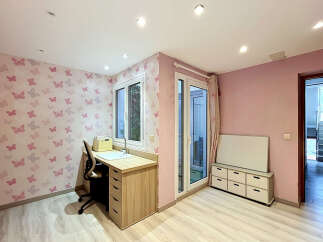 This charming room features a playful butterfly-themed wallpaper, creating a whimsical atmosphere.