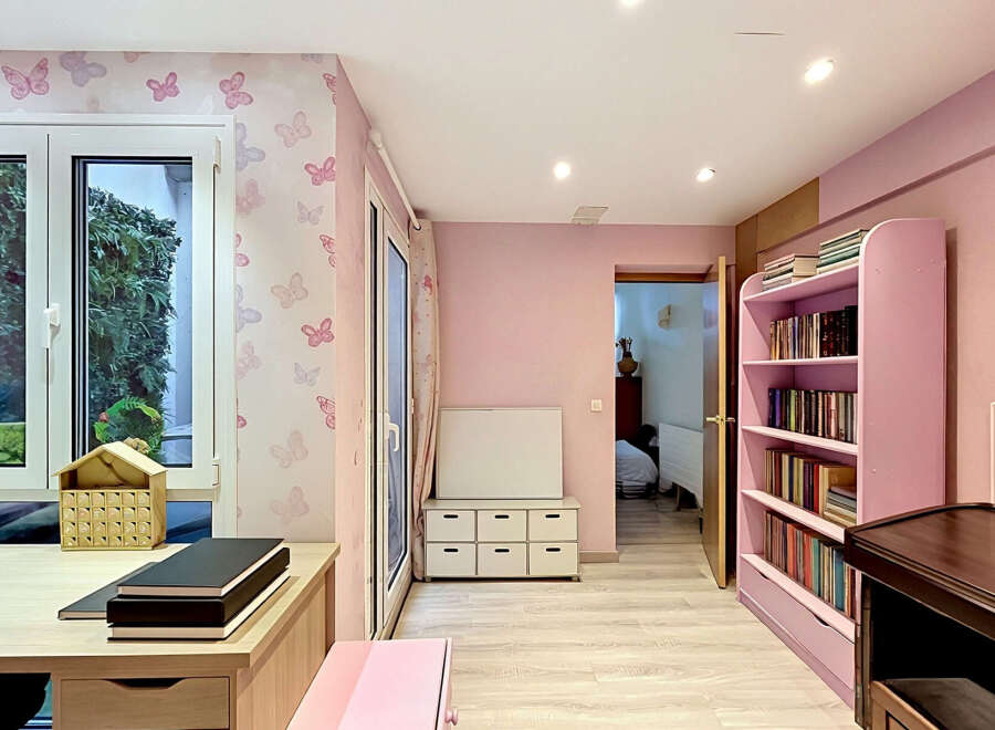 Step into a charming room designed with a delightful pink butterfly-themed wallpaper, creating a whimsical and inviting atmosphere.