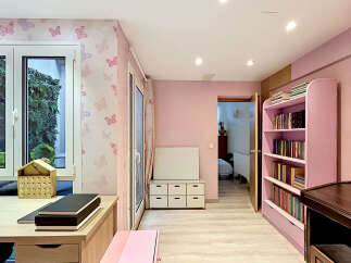 Step into a charming room designed with a delightful pink butterfly-themed wallpaper, creating a whimsical and inviting atmosphere.