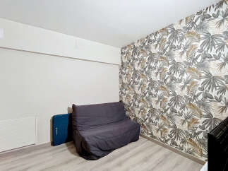 This room features a stylish dark grey sofa bed, perfect for maximizing space in a modern living area.