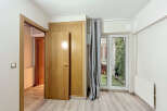 Discover this charming room featuring a light wood door and a built-in closet, offering ample storage solutions.