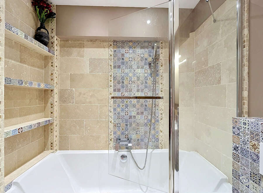 Experience luxury in this stunning bathroom, featuring a deep soaking tub complemented by a sleek glass shower enclosure.