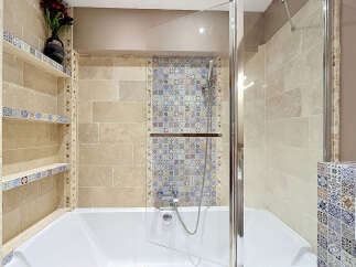 Experience luxury in this stunning bathroom, featuring a deep soaking tub complemented by a sleek glass shower enclosure.