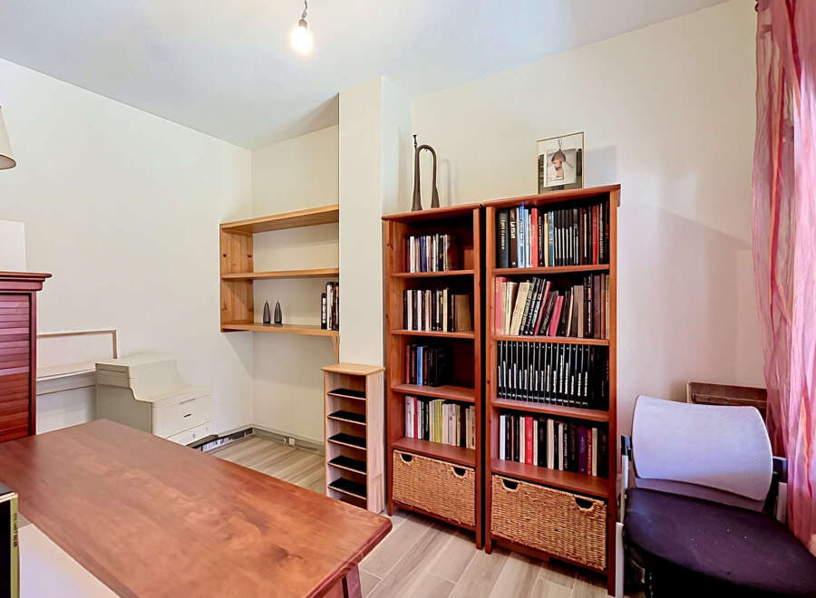 Discover a versatile space perfect for a home office or study, featuring a large wooden desk and ample storage solutions.