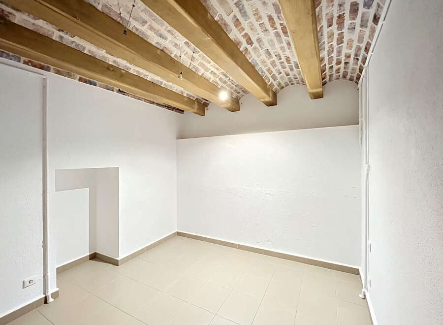 Discover this charming room featuring exposed wooden beams and a rustic brick ceiling, adding character and warmth.