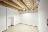 Discover this charming room featuring exposed wooden beams and a rustic brick ceiling, adding character and warmth.