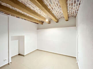 Discover this charming room featuring exposed wooden beams and a rustic brick ceiling, adding character and warmth.