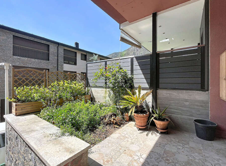 Discover this charming outdoor space featuring lush greenery and decorative planters, perfect for relaxing or entertaining.