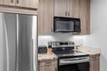 Experience modern living in this beautifully appointed kitchen, featuring sleek stainless steel appliances including a Fisher & Paykel refrigerator and a GE microwave.
