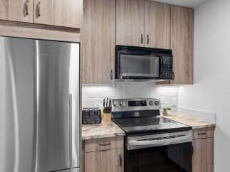 Experience modern living in this beautifully appointed kitchen, featuring sleek stainless steel appliances including a Fisher & Paykel refrigerator and a GE microwave.
