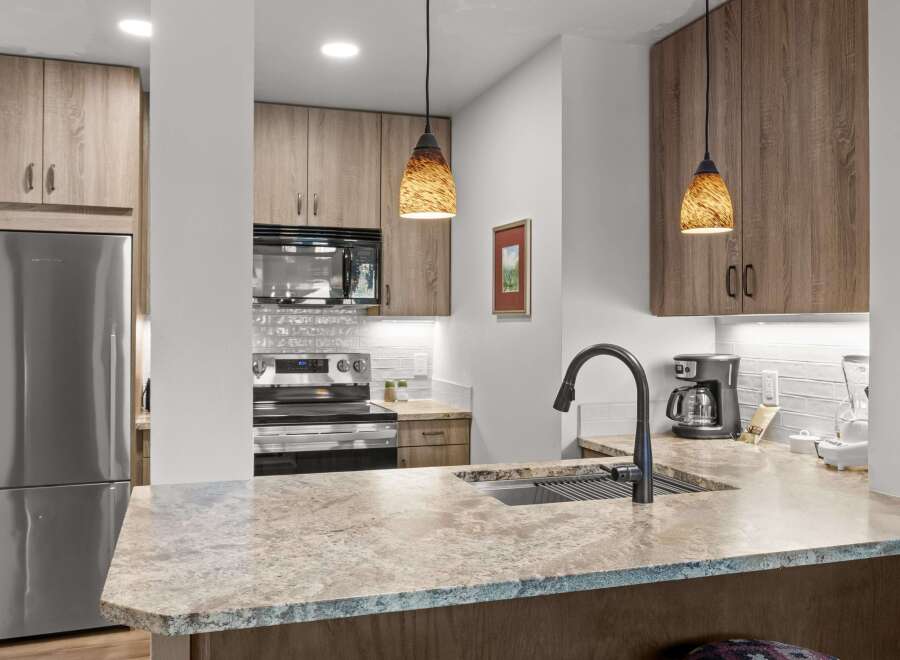 Experience modern living in this stunning kitchen featuring sleek stainless steel appliances, including a refrigerator, microwave, and oven.