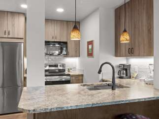 Experience modern living in this stunning kitchen featuring sleek stainless steel appliances, including a refrigerator, microwave, and oven.