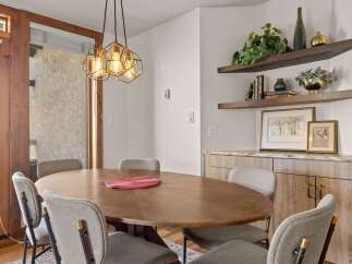 This dining area features a stylish oval wooden table surrounded by comfortable upholstered chairs, perfect for intimate gatherings.